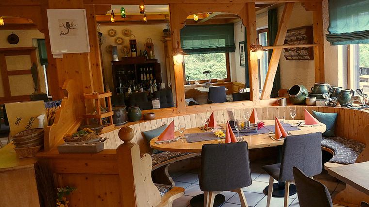 Un restaurant confortable avec des meubles en bois et une atmosphère accueillante. La table est joliment dressée avec de petits drapeaux et les murs sont décorés.