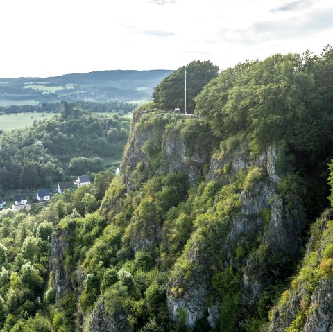 Blick auf das Munterley Plateau mit bewaldeten Klippen und H&auml;usern im Tal.