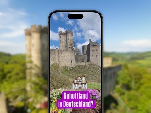 Vor dem verschwommenen Hintergrund ist ein Handy, welches auf Instagram das Reel zum Wanderweg Felsenpfad zeigt.